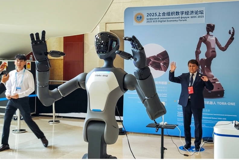 2025 상하이협력기구(SCO) 경제포럼이 7월 11일 톈진시에서 열렸을 때, 한 방문객이 인터랙티브 체험 구역에서 휴머노이드 로봇과 교류하고 있다. 사진/VCG